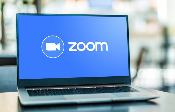 Laptop computer displaying logo of Zoom.